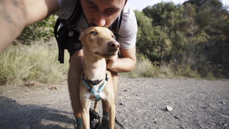 Hispanic-owner-petting-a-baby-hound-puppy-while-vlogging-in-the-woods