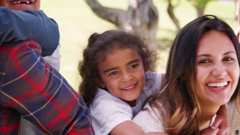 multi generation family piggybacking with kids, panning shot