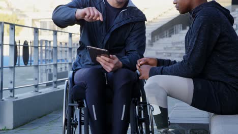 Two-disabled-athletics-discussing-over-digital-tablet-4k