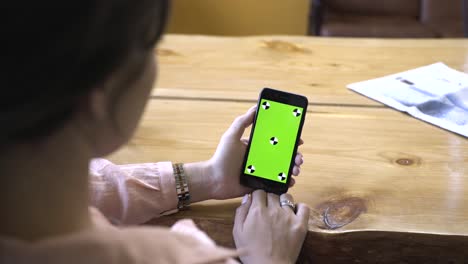 woman holding smartphone with green screen