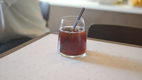 a glass of iced tea on a table in a cafe