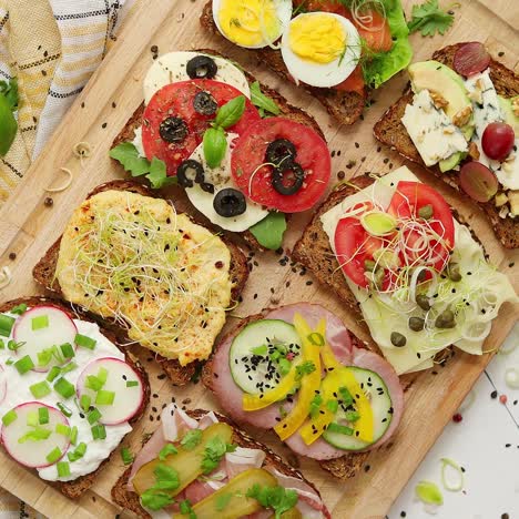 tasty  homemade small sandwiches with various ingredients served on wooden chopping board