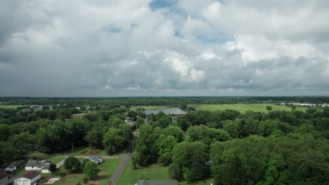 on a cloudy day, a drone captures the town from a great height, surrounded by tall trees