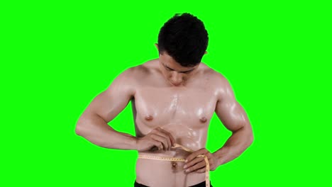 un joven musculoso midiendo su cintura