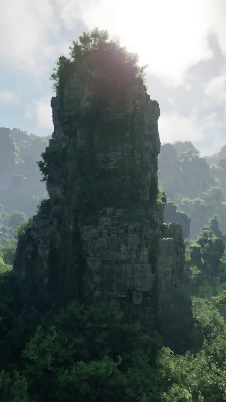 una alta y dramática formación rocosa se eleva desde un paisaje boscoso, con un sol brillante brillando en el fondo.