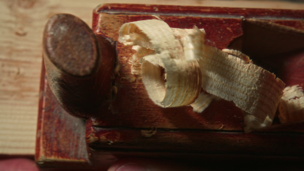 Close Up of Craftsman Using Planer to Smooth Wooden Plank