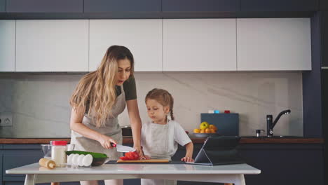 mother-in-an-apron-in-kitchen-at-table-with-ingredients