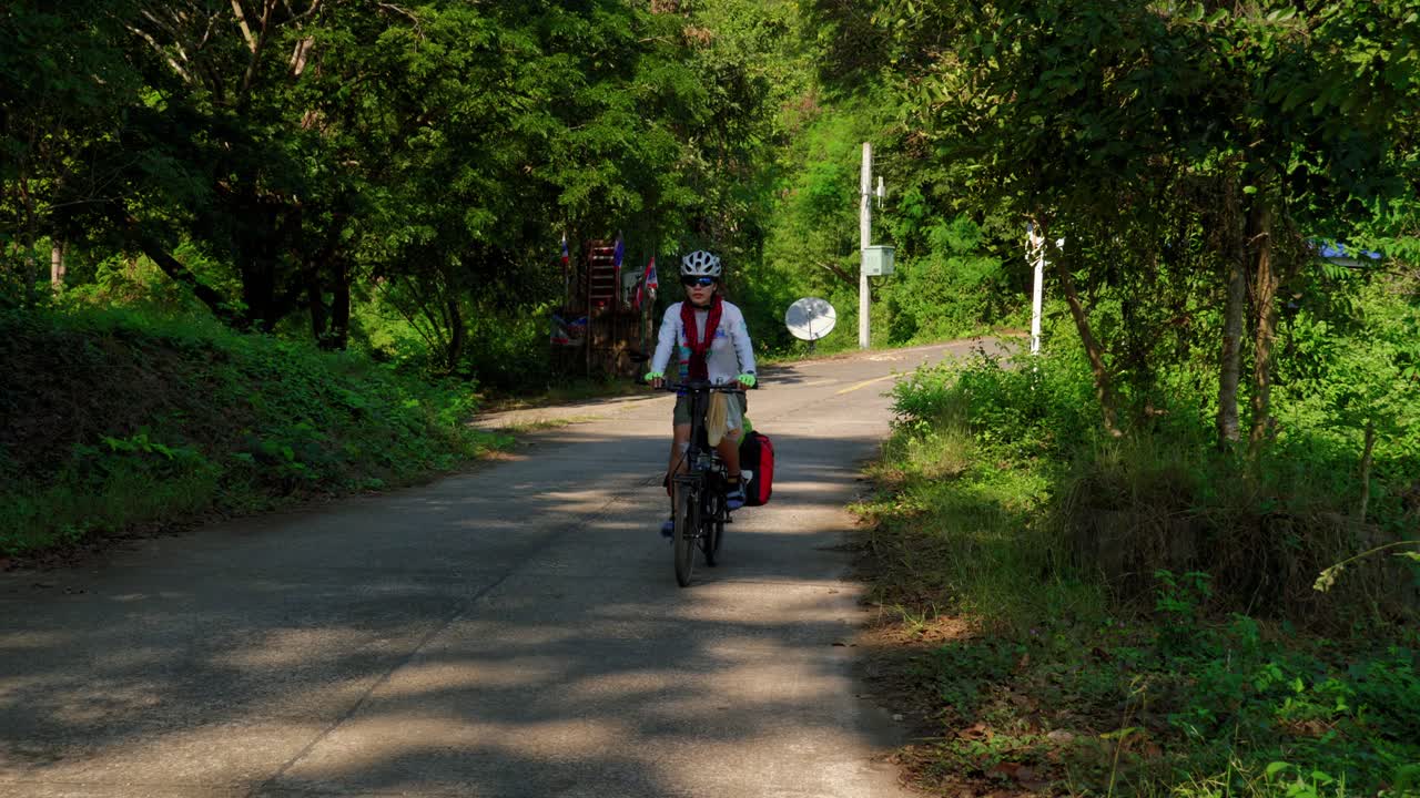 태국 난성 팍 나이 어촌 마을의 숲길에서 자전거 타는 여성의 전경