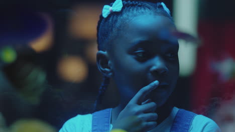 black-girl-looking-at-fish-in-aquarium-curious-child-watching-colorful-sea-life-swimming-in-tank-learning-about-marine-animals-in-underwater-ecosystem-inquisitive-kid-at-oceanarium