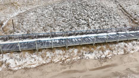 a lakeside wood boardwalk covered in snow