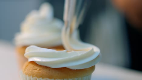 Zuckerguss-Wird-Auf-Einen-Cupcake-Gespritzt