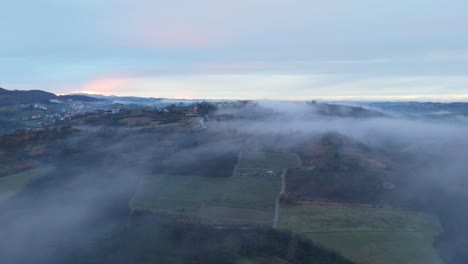 Mist-cloud-hovering-over-early-morning-countryside-village-landscape