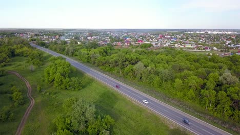 aerial view of a road passing through a town and forest