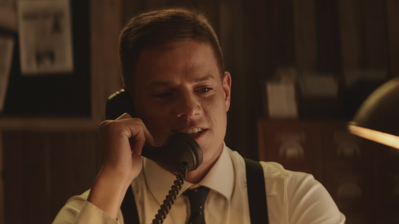 레트로 사무실에서 빈티지 전화로 말하는 남자