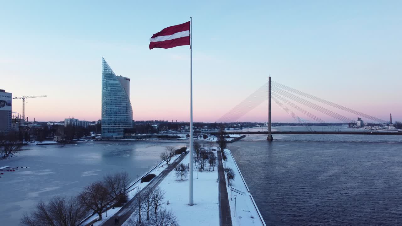 Kışın bayrak direğinde dalgalanan vatansever Letonya bayrağı, ulusal bağımsızlık gününü kutluyor.