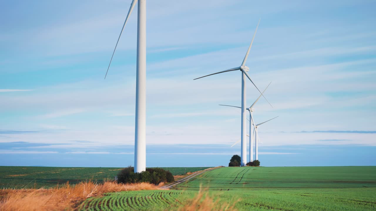 풍력 터빈 탑은 신선한 녹색 을 가진 농장  위에 있습니다.