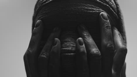 a mummified woman against the bright background in keeps her hands on her face the powerful pose full of despair