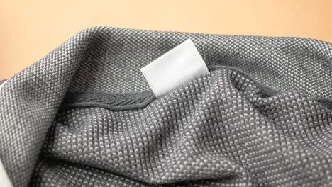 etiqueta de cuidado en blanco en camiseta de polo gris
