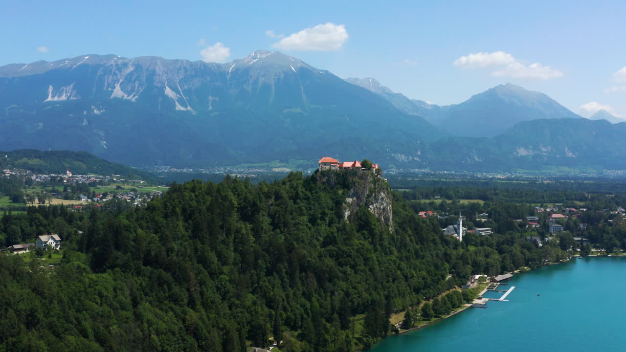 Museo del Castello di Bled a picco con fitta vegetazione che domina il Lago di Bled in Slovenia con una splendida catena montuosa sullo sfondo