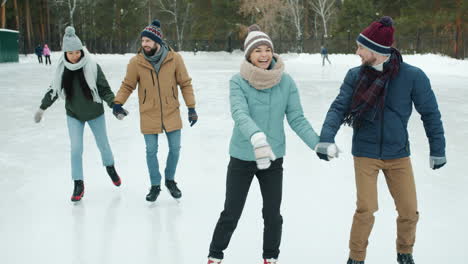 friends ice skating in winter park