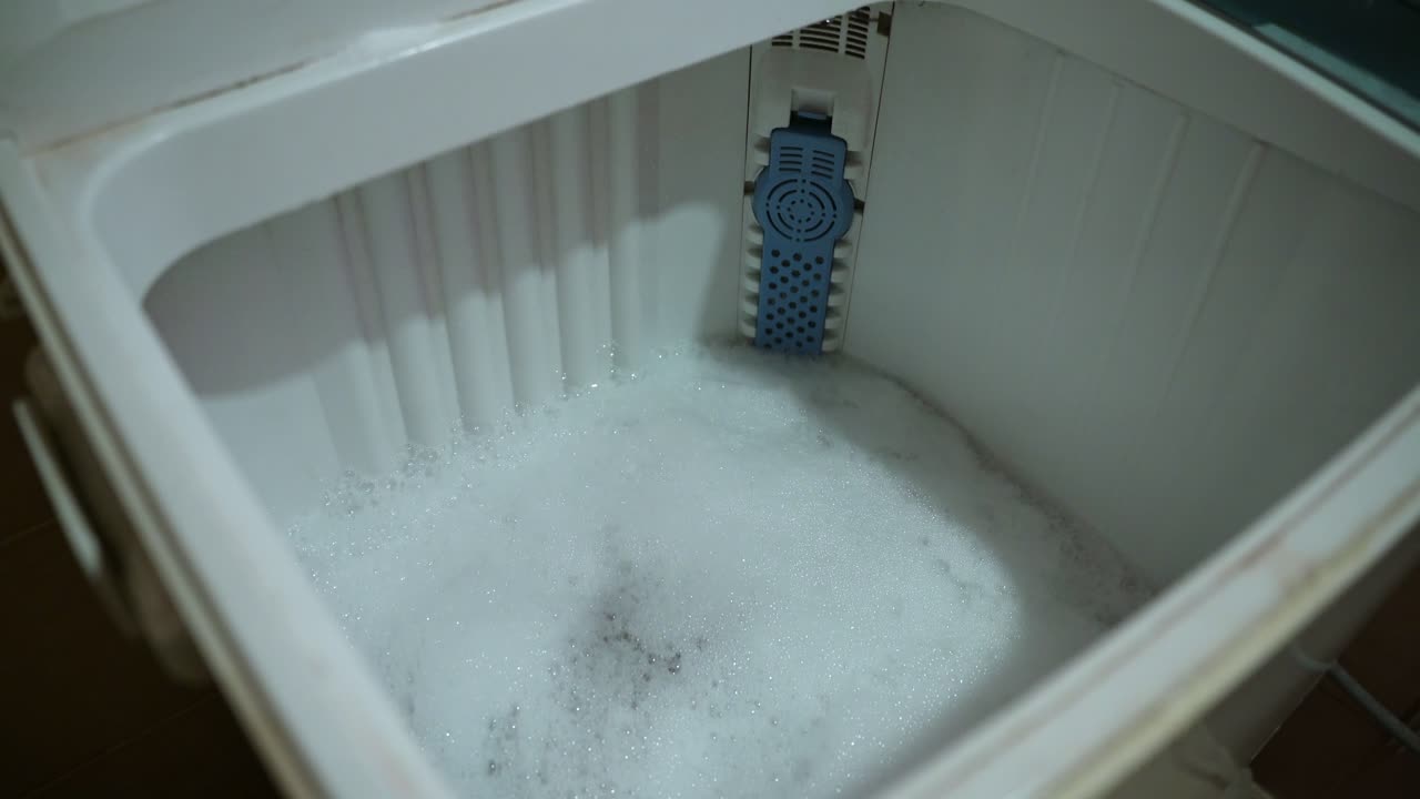 Foamy detergent swirling in a washing machine drum—perfect for cleaning, appliance, or utility scenes