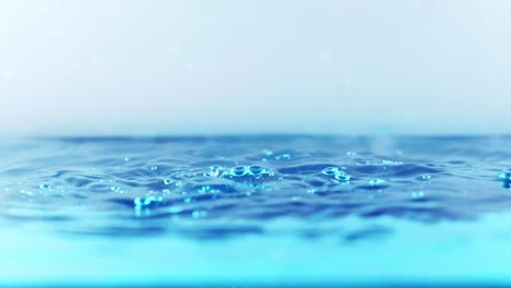 the clean water surface in slow motion fills the screen with water splashing shop the water drop and waving liquid surface with an air bubble