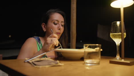 woman having dinner at the restaurant outdoor under warm light