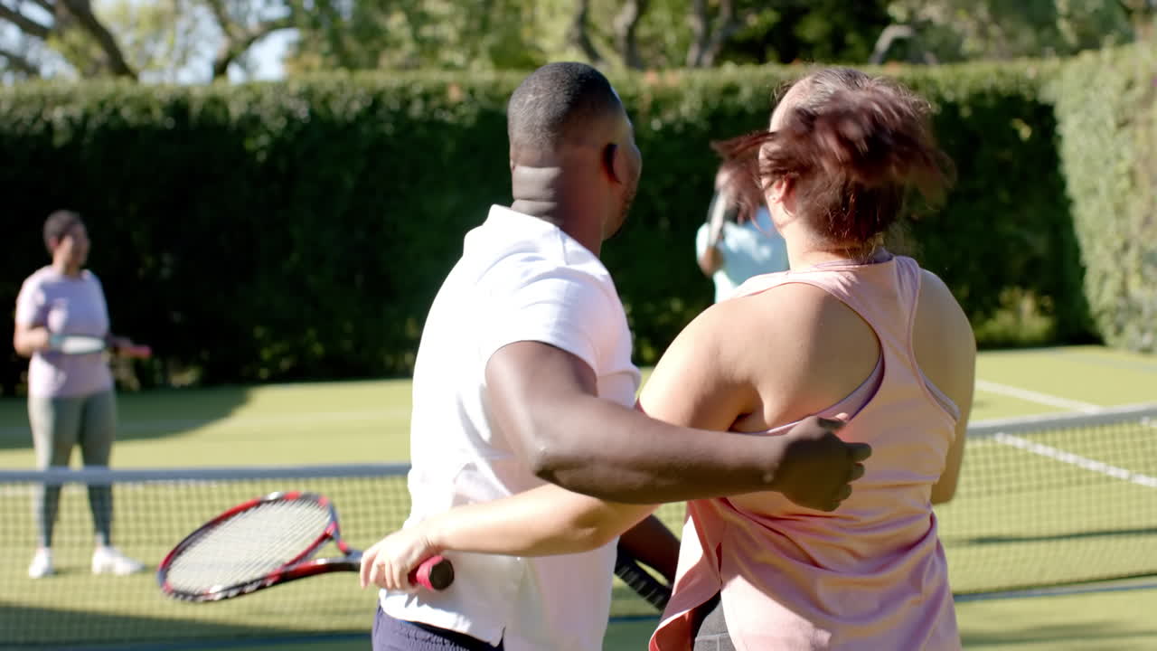 Playing doubles tennis, Diverse Friends celebrating point on outdoor school court