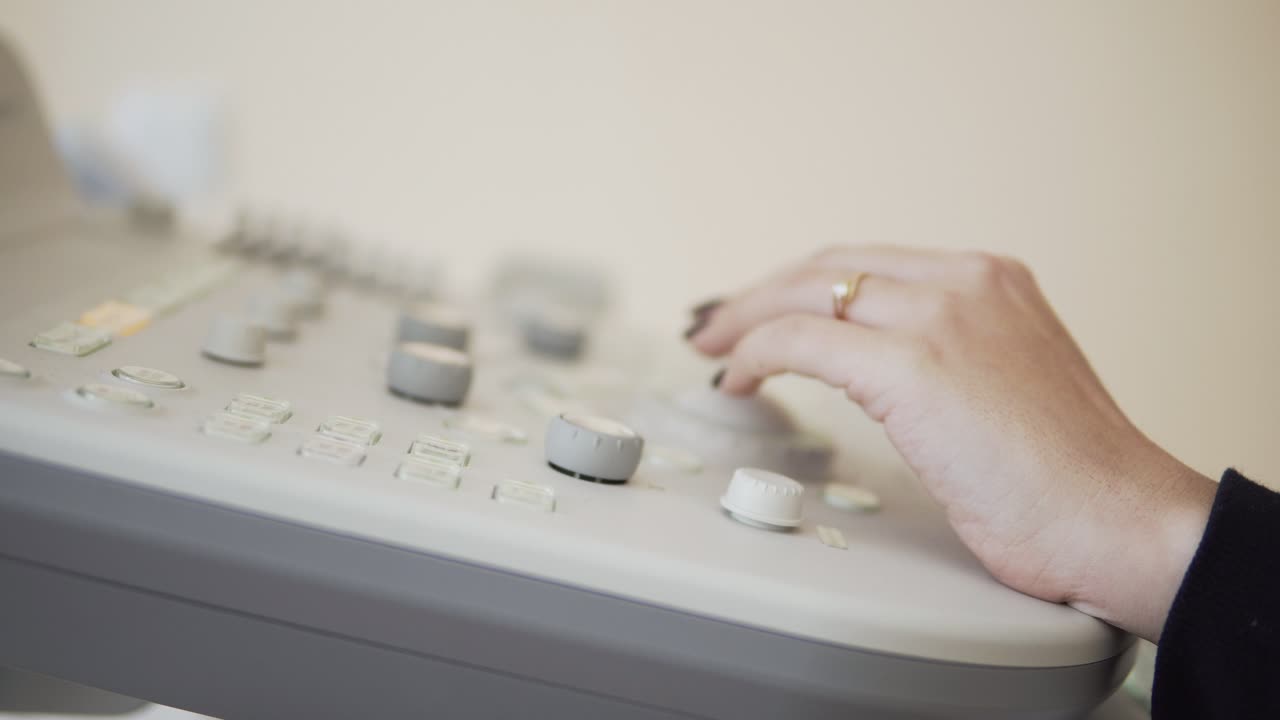 teclado del dispositivo de ultrasonido, manos de un médico irreconocible que trabaja con equipos de ultrasonido