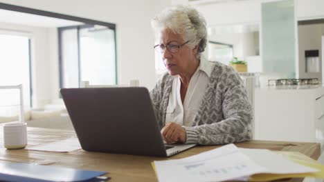 Nachdenkliche-Afroamerikanische-ältere-Frau,-Die-Zu-Hause-Einen-Laptop-Benutzt
