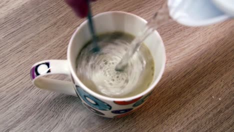 mixing cappuccino with a spoon