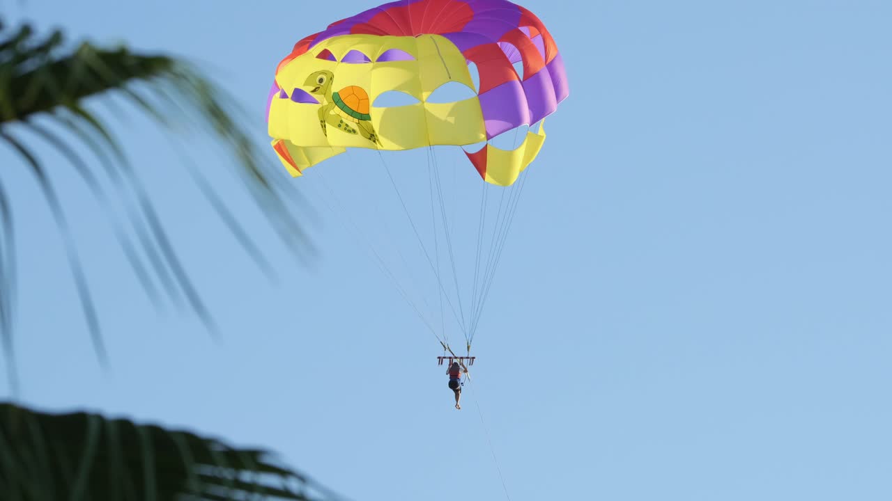 parasailer volando en paracaídas de colores en el cielo del atardecer o del amanecer