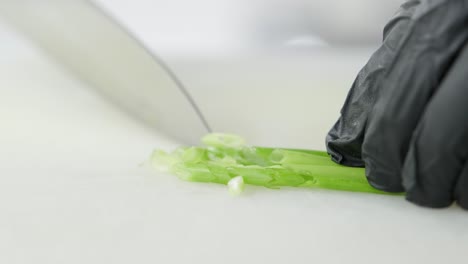 cook cuts green onions with a knife