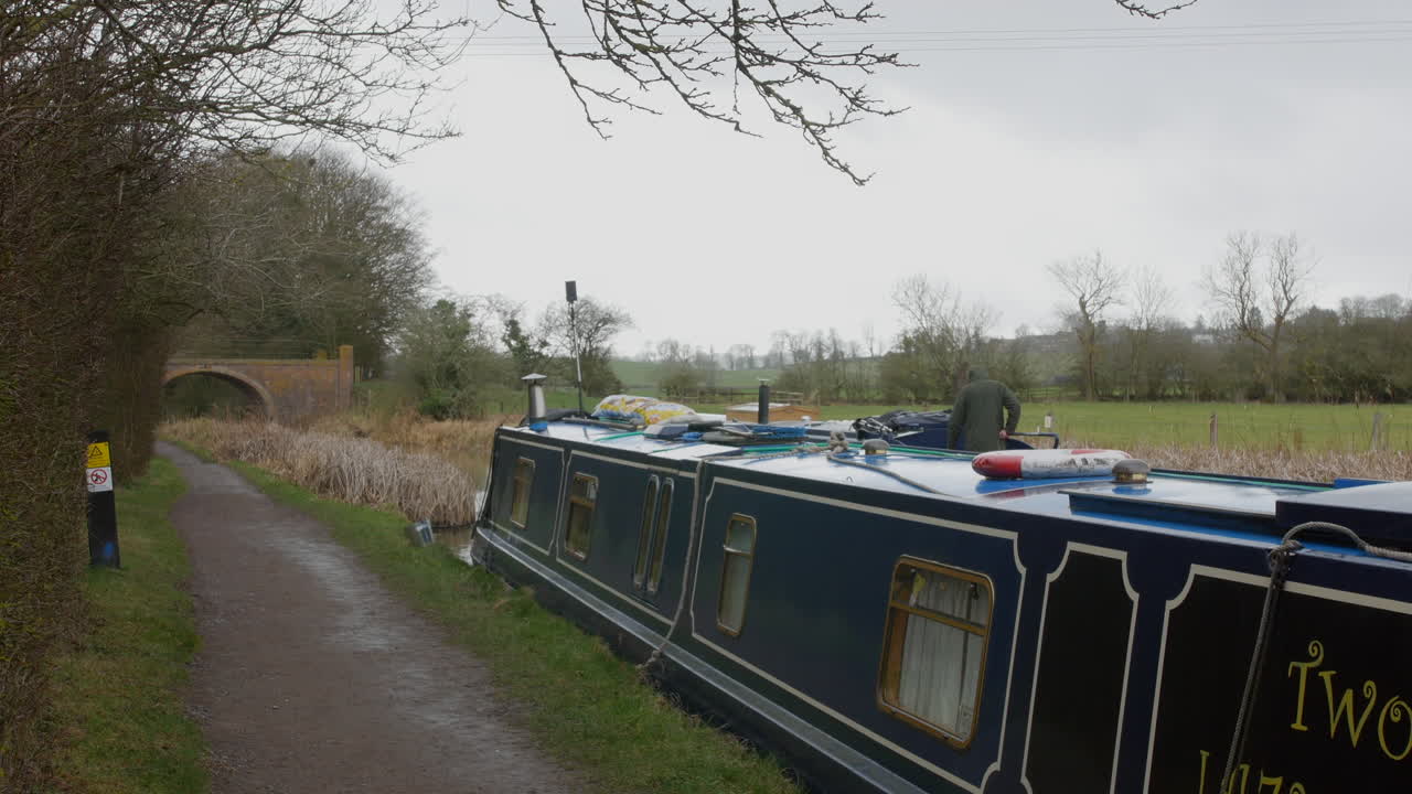 빗 속에서 다리를 향해 강을 따라 지나가는 운하 좁은 집 보트