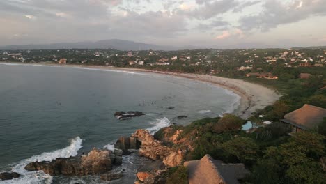 Drone-Aéreo-La-Punta-Zicatela-Playa-De-Arena-Tropical-En-Puerto-Escondido-México-Oaxaca-Viajes-Destinos-De-Vacaciones-Llenos-De-Resort