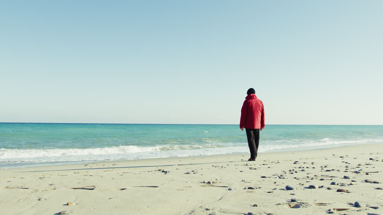 Elderly Man in a Jacket Takes a Walk by the Sea
