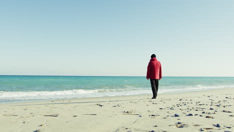 elderly man in a jacket takes a walk by the sea