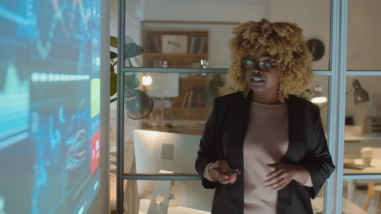 African American Woman Giving Business Presentation at Night Meeting