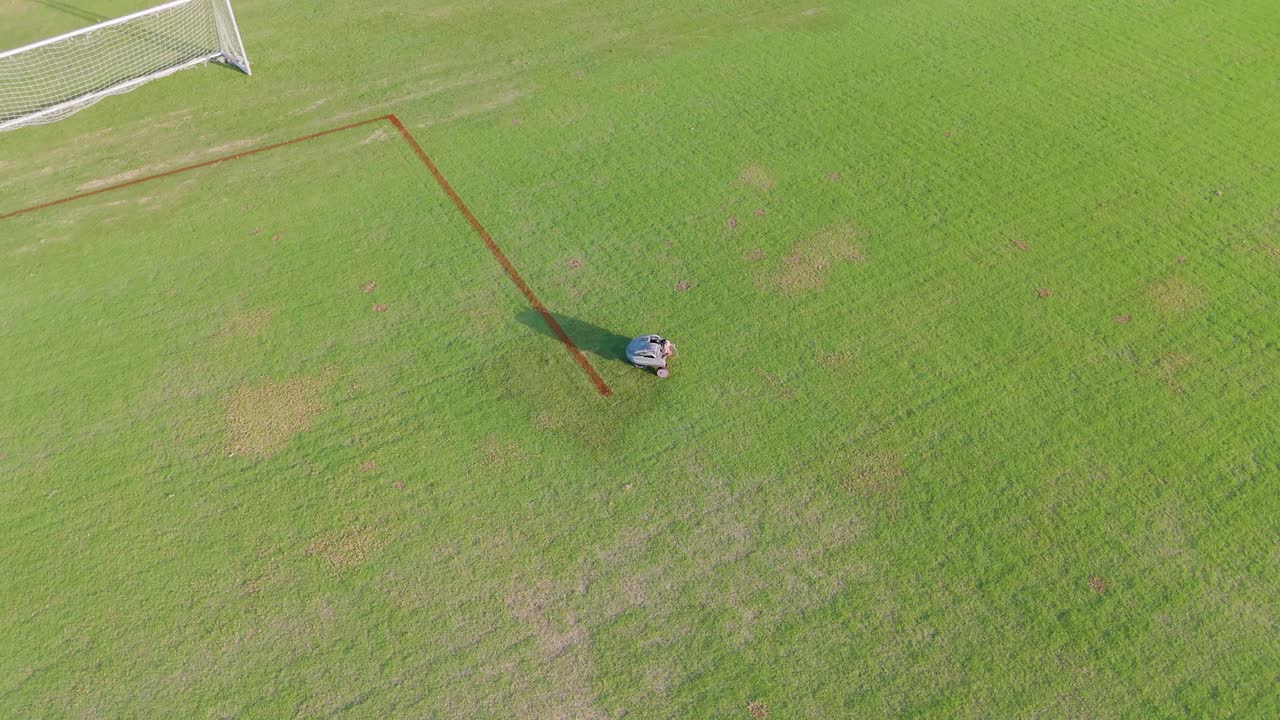 A robot autonomously paints lines on a soccer field, showcasing precision and efficiency in field maintenance