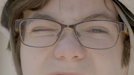 closeup of a cute boy wearing a bike helmet and glasses turning to look towards camera