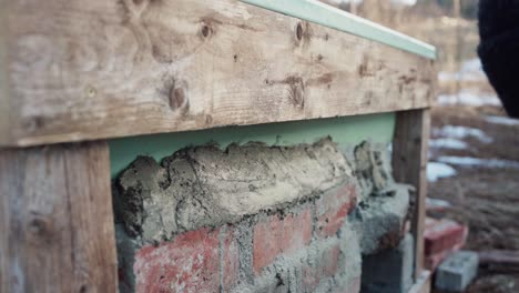 Worker-With-Trowel-Putting-Mortar-Paste-On-Top-Of-Brick-Stones