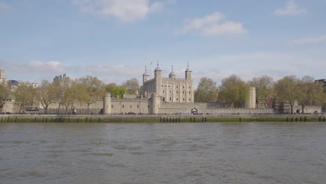 view of skyline and tower of london from tourist boat on river thames 2