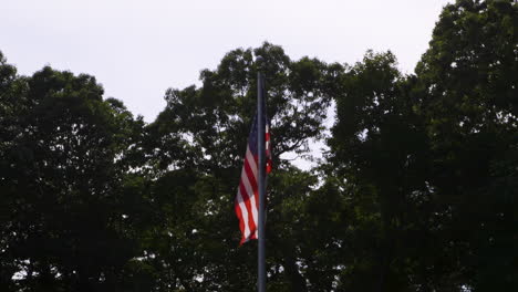 united states flag hanging from a flagpole on a hot and hazy summer day