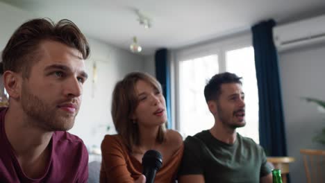 amigos adultos jóvenes cantando en casa el karaoke.