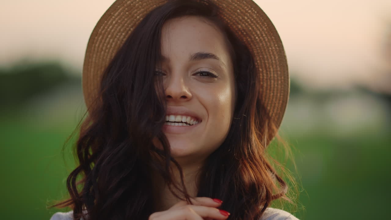 retrato de una mujer juguetona sonriendo al aire libre. una mujer joven mirando a la cámara