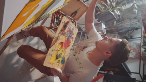 young man painting in art studio