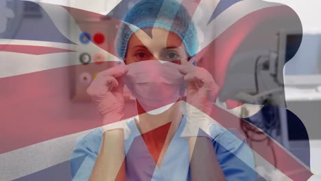 Animation-of-uk-flag-over-female-doctor-wearing-face-mask