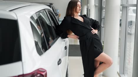 una joven vestida mira por la ventana de un auto nuevo