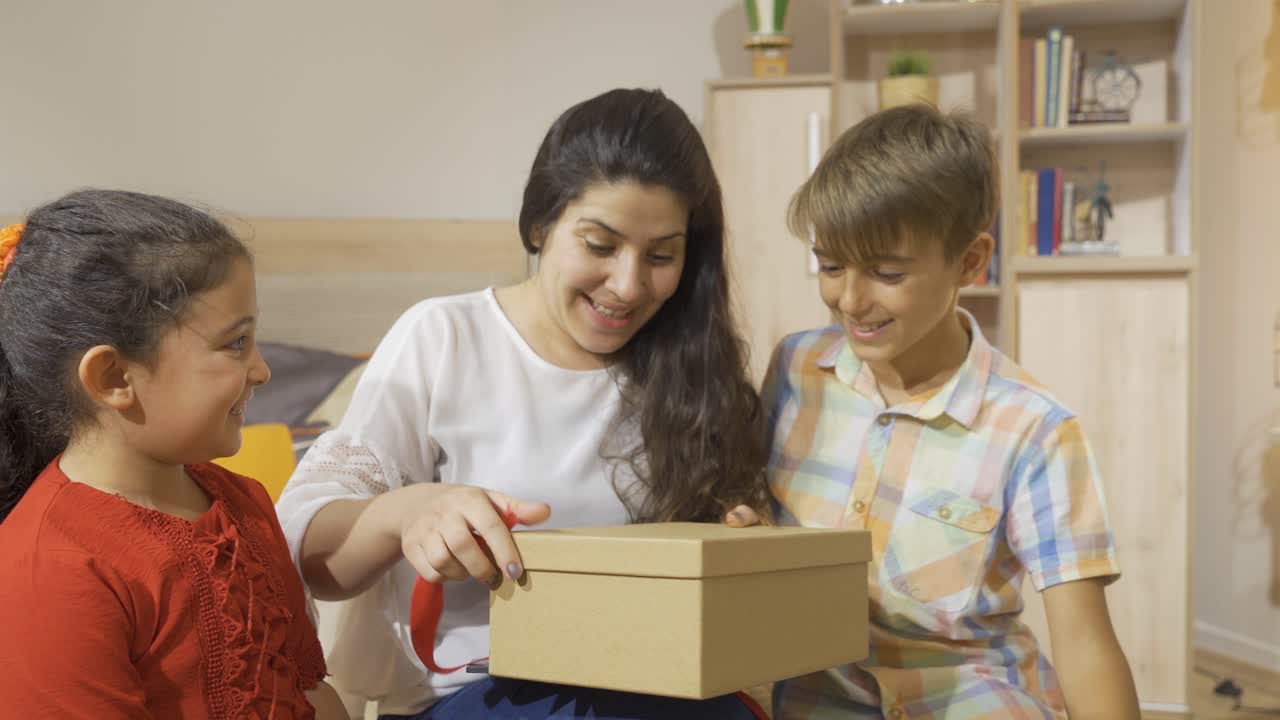 niños dando cajas de regalos a sus madres.
