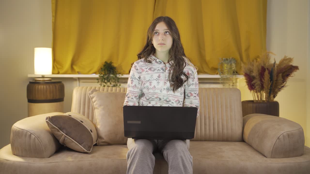 Unhappy young woman using laptop laptop at night. It's not in a good mood.